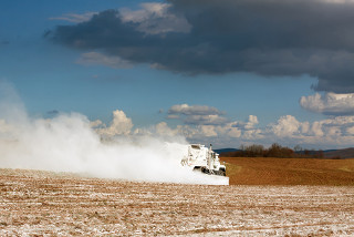Um caminhão espalhando calcário em pó na terra para melhorar as propriedades do solo, em Lancaster County, Pensilvânia, EUA.